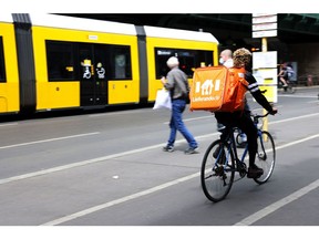 A Just Eat Takeaway.com NV Lieferando.de food delivery cyclist rides beside a tram in Berlin, Germany, on Monday, May 24, 2021. The online food delivery sector has emerged as one of the few industries to flourish during the pandemic, as restaurants stay shut and people get tired of pasta.