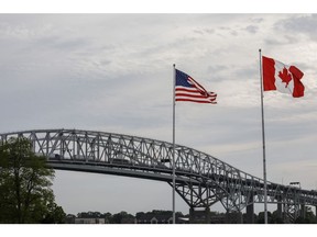 Canadian and U.S. flags fly at the base of the Bluewater Bridge, which connects Canada and the U.S., near the Enbridge Line 5 pipeline in Sarnia, Ontario, Canada, on Tuesday, May 25, 2021. Enbridge Inc. said it will continue to ship crude through its Line 5 pipeline that crosses the Great Lakes, despite Michigan Governor Gretchen Whitmer's order to shut the conduit.