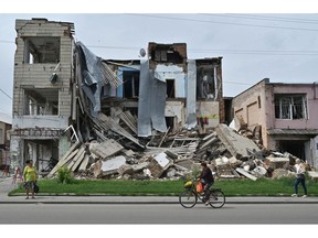 Pedestrians walk past a destroyed store in the city of Okhtyrka, Sumy region on August 1, 2022. Photographer: Genya Savilov/AFP/Getty Images