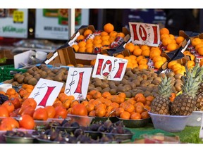 Signs advertise prices of fruit at a market stall in Croydon, Greater London.