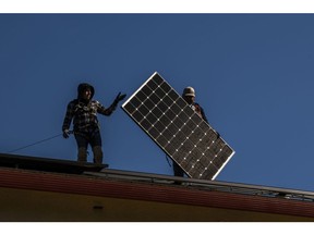 Save A Lot Solar contractors install LG Electronics solar panels on a home in Hayward, California, U.S., on Tuesday, Feb. 8, 2022. California regulators are delaying a vote on a controversial proposal to slash incentives for home solar systems as they consider revamping the measure.
