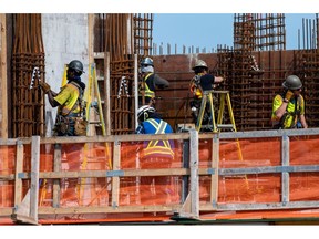 Workers on a condo building under construction in downtown Victoria, British Columbia, Canada, on Thursday, April 7, 2022. Benchmark home prices rose a record 3.5% in February, with transactions jumping 4.6% during the month, according to data from the Canadian Real Estate Association.