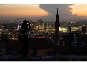 A visitor photographs the city skyline from Ankara castle at dusk in Ankara, Turkey, on Tuesday, May 31, 2022. Turkey's inflation soared in May to the fastest since 1998 as it came under more pressure from the rising cost of food and energy while ultra-loose monetary policy contributed to currency weakness. Photographer: SeongJoon Cho/Bloomberg