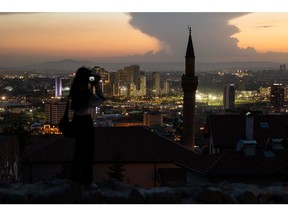 A visitor photographs the city skyline from Ankara castle at dusk in Ankara, Turkey, on Tuesday, May 31, 2022. Turkey's inflation soared in May to the fastest since 1998 as it came under more pressure from the rising cost of food and energy while ultra-loose monetary policy contributed to currency weakness. Photographer: SeongJoon Cho/Bloomberg