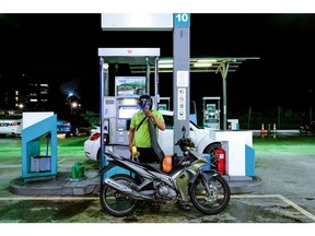 A customer refuels RON95 petrol at a Petroliam Nasional Bhd. (Petronas) gas station in Shah Alam, Selangor, Malaysia, on Thursday, June 9, 2022. Malaysia has begun work on replacing its blanket petrol and cooking oil subsidies with a more targeted approach, as government spending rises to blunt higher living costs.