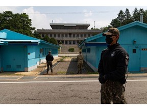 South Korean and United Nations Command (UNC) soldiers stand guard next to the United Nations Command Military Armistice Commission (UNCMAC) conference buildings at the truce village of Panmunjom in the Demilitarized Zone (DMZ) in Paju, South Korea, on Tuesday, July 19, 2022. South Korean prosecutors are investigating members of former President Moon Jae-in's government over the 2019 forced repatriation of two North Koreans, whose return to face criminal charges and likely execution had been denounced by critics as a violation of human rights.