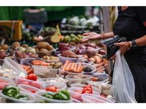 A customer pays for fresh produce at a grocery stall on Surrey Street Market in Croydon, UK, on Monday, July 25, 2022. UK inflation running at the fastest pace since the early 80s. Photographer: Hollie Adams/Bloomberg