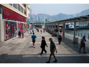Pedestrians along a road in the Tsim Sha Tsui area in Hong Kong, China, on Sunday, July 31, 2022. Hong Kong is scheduled to release retail sales figures on Aug. 2. Photographer: Billy H.C. Kwok/Bloomberg
