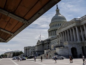Pedestrians walk past the US Capitol building in Washington, D.C., US, On Saturday, Aug. 6, 2022. The Senate is in for a rare weekend session as Democrats look to pass their tax, climate, and drug-pricing bill through the budget reconciliation process. Photographer: Ting Shen/Bloomberg