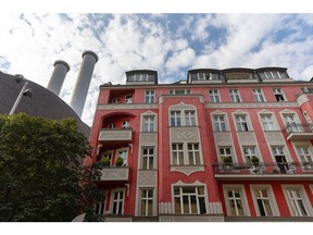 Chimney stacks at the Mitte Combined Heat and Power (CHP) natural gas power plant, operated by Vattenfall AB, behind apartment buildings in central Berlin, Germany, on Tuesday, Aug. 9. 2022. German Finance Minister Christian Lindner said he will look at ways of exempting the country's looming gas levy from sales tax in an effort to at least partially ease the burden on consumers from soaring energy costs.