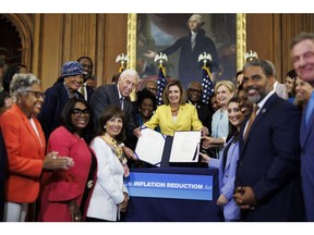 House Speaker Nancy Pelosi holds the bill H.R. 5376, the Inflation Reduction Act of 2022, after signing it at the US Capitol on August 12.