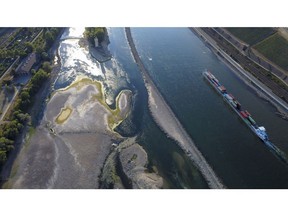 A barge travels past exposed riverbed on the River Rhine near Bingen, Germany, on Friday, Aug. 12, 2022. The Rhine River fell to a new low on Friday, further restricting the supply of vital commodities to parts of inland Europe as the continent battles with its worst energy crisis in decades.