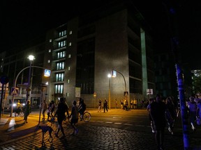 Pedestrians and visitors lit by street lamps at night in the Government District of Berlin, Germany, on Tuesday, Aug. 16, 2022. Germany's government has asked citizens, municipalities and industrial consumers to save energy, and efforts can be seen across the country. Photographer: Krisztian Bocsi/Bloomberg