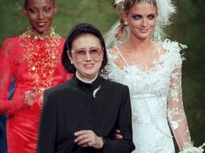 FILE - Japanese fashion designer Hanae Mori, center, is applauded by models after the presentation of her 1997-98 fall-winter haute couture collection presented in Paris, July 9, 1997. Mori, known for her elegant signature butterfly motifs, has died, according to local media reports. She was 96.