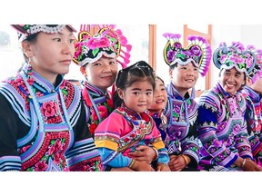 Women from the Art Ensemble "Huobonuoma," or "Daughters of the Moon," showcasing their Yi embroidered costumes, an ancient handcraft representing the cultural heritage of the Yi ethnic group.