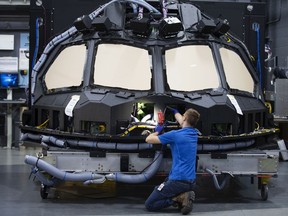 An employee inspects a Boeing Co. 787 cockpit shell and main instrument panel (MIP) at a CAE Inc. facility in Montreal, in 2019.