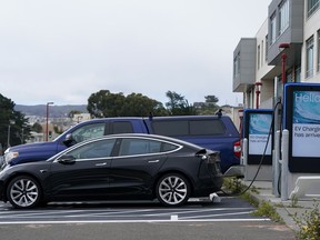 Cars are parked at an electric charging station in San Francisco, Thursday, Aug. 25, 2022. California is poised to required 100% of new cars, trucks and SUVs sold in the state to be powered by electricity or hydrogen by 2035.
