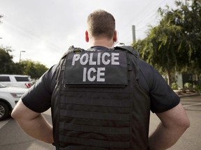 FILE - A U.S. Immigration and Customs Enforcement (ICE) officer looks on during an operation in Escondido, Calif., July 8, 2019. Data broker LexisNexis Risk Solutions allegedly violated Illinois law by collecting and combining extensive personal information and selling it to third parties including federal immigration authorities, according to a lawsuit filed Tuesday, Aug. 16, 2022, by immigration advocates.