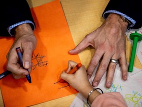 Prime Minister Justin Trudeau holds a crayon after he played, and lost, a game of tic-tac-toe against a child, following a new child-care deal announcement in Ontario.