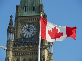 The federal government posted a surplus of $10.2 billion in the first quarter of the fiscal year. A Canadian flag flies near the Peace Tower on Parliament Hill in Ottawa on Wednesday, Oct. 23, 2019.
