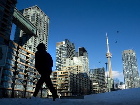 Condo towers dot the Toronto skyline as a pedestrian makes his way on Thursday January 28, 2021. Urbanation Inc. expects 10,000 Greater Toronto Area condo units to be shelved this year as increasing mortgage rates weigh on home sales.
