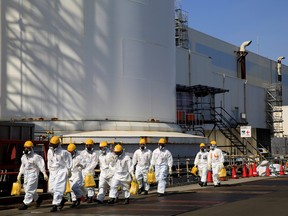 Workers walk near No. 2 and No. 3 reactor buildings at the tsunami-crippled Fukushima Daiichi nuclear power plant in Okuma town, Fukushima prefecture, Japan March 1, 2021.