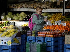 FILE - A woman selects fruits at a supermarket in London, Wednesday, Nov. 17, 2021. The Office for National Statistics said Wednesday, Aug. 17, 2022, that consumer prices inflation hit double digits, a jump from 9.4% in June and higher than analysts' central forecast of 9.8%. The increase was largely due to rising prices for food and staples including toilet paper and toothbrushes, it said.