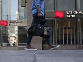 A pedestrian walks past a National Bank of Canada branch in the financial district of Toronto.