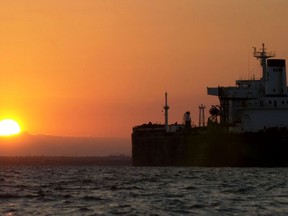 An oil tanker is silhouetted as the sun rises over Lake Maracaibo, Venezuela, on Friday, December 13, 2002. Tanker owners are heading for the second-best year since the 1973 Arab oil embargo, with rising crude-oil demand during the coldest months in the U.S. and Europe set to fuel fourth-quarter profits. Photographer Diego Giudice/Bloomberg News Photographer: DIEGO GIUDICE