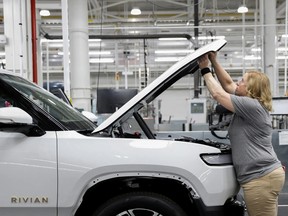 An employee works on an assembly line at startup Rivian Automotive's electric vehicle factory in Normal, Illinois.