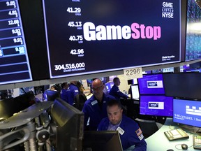 Traders work under signage for GameStop Corp. on the trading floor at the New York Stock Exchange in Manhattan, New York City, U.S.