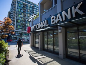 A pedestrian passes in front of a National Bank of Canada branch in Richmond, B.C.