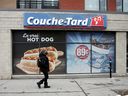 A pedestrian walks past an Alimentation Couche-Tard Inc. store.  convenience store in Montreal, Que.