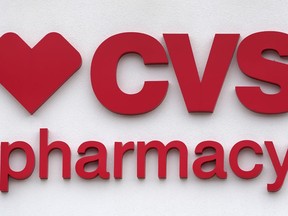 FILE - The CVS Pharmacy logo is displayed on a store on Aug. 3, 2021, in Woburn, Mass. A nurse practitioner from northern Virginia sued CVS Health on Wednesday, Aug. 31, 2022, saying she was fired for refusing to provide abortion-inducing drugs at its MinuteClinic medical facilities.