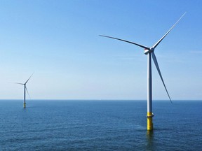FILE - Two of the offshore wind turbines which have been constructed off the coast of Virginia Beach, Va. are viewed June 29, 2020. State regulators on Friday, Aug. 5, 2022, approved an application from Dominion Energy Virginia to build an enormous offshore wind farm off the coast of Virginia Beach and recover the cost from ratepayers.