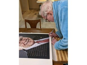 FILE - Billionaire Warren Buffett signs a portrait of himself that is being auctioned off to raise money for one of his favorite charities, Girls Inc. of Omaha, Neb. The portrait of Buffett features a grid of letters over the picture that light up to spell out several of the legendary investor's famous quotes. The eBay auction of this artwork probably won't rival the $19 million someone paid earlier this year for a private lunch with Buffett, but it's still likely to attract big bidders among the Berkshire Hathaway CEO's devoted followers.CEO's devoted followers. (Motiva Art via AP)