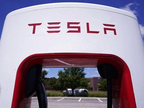 Tesla Supercharger is seen at Willow Festival shopping plaza parking lot Wednesday, Aug. 10, 2022, in Northbrook, Ill. Tesla is splitting its stock 3 for 1, so after the close of trading Tuesday, Aug. 23, investors will receive two additional Tesla shares for every one they owned as of Aug. 17. In theory, that should drop Tesla's share price by about two-thirds before trading starts on Wednesday.