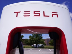 Tesla Supercharger is seen in the parking lot of the Willow Festival mall Wednesday, August 10, 2022, in Northbrook, Illinois. Tesla is splitting its stock 3 for 1, so after the close of trading on Tuesday, August 23, investors will receive two more Tesla Shares for each share they owned on August 17. In theory, that should send Tesla's stock price down about two-thirds before trading begins on Wednesday.