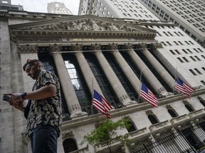 FILE - Pedestrians walk past the New York Stock Exchange, on July 8, 2022, in New York. Stocks are opening lower on Wall Street Wednesday, Aug. 17, as traders absorb some discouraging news about how much Americans are spending.