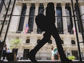 A pedestrian walks past the New York Stock Exchange in New York City, Thursday, Aug. 18, 2022. Major indexes were held back by mostly choppy trading following a weeklong run of gains.