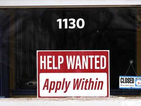 FILE - A "help wanted" sign is seen at an Allstate insurance office in Elgin, Ill., March 19, 2022. American employers posted fewer job openings in June as the economy contends with raging inflation and rising interest rates. Job openings fell to a still-high 10.7 million in June from 11.3 million in May, the Labor Department said Tuesday, Aug. 2, 2022.