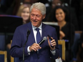 FILE - Former President Bill Clinton smiles as he plays a recording of Aretha Franklin on his phone during the funeral service for Franklin at Greater Grace Temple, Friday, Aug. 31, 2018, in Detroit. World Central Kitchen founder Jose Andres, Jordan's Queen Rania, BlackRock CEO Larry Fink and "Hamilton" creator Lin-Manuel Miranda will help relaunch the Clinton Global Initiative in Sept. 2022, when the gathering of international dignitaries returns after six years.