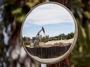 An oil pumpjack is reflected in a mirror as it operates on August 5, 2022 near Ventura, California.