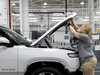 An employee works on an assembly line at startup Rivian Automotive’s electric vehicle factory in Normal, Ill. The southern Californa EV automaker said it is planning to cut hundreds of non-manufacturing jobs and teams with duplicate functions.