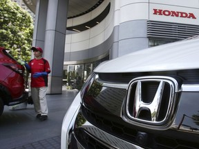 FILE - An employee of Honda Motor Co. cleans a Honda car displayed at its headquarters in Tokyo on July 31, 2018. Honda's fiscal first quarter profit fell 33% from 2021 as a global computer chip shortage, a pandemic-related lockdown in China and the rising costs of raw materials hurt the Japanese automaker. Tokyo-based Honda Motor Co. reported Wednesday, Aug. 10, 2022, that its profit totaled 149.2 billion yen ($1.1 billion) in the April-June quarter, down from 222.5 billion yen ($1.7 billion) a year earlier. Quarterly sales slipped 7% to 3.8 trillion yen ($28 billion).