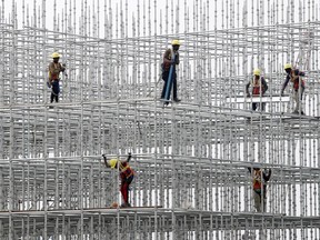 FILE - Construction workers prepare a scaffolding at a construction site at Hajji Ali in Mumbai, India, on Jan. 8, 2022. India's central bank on Wednesday, Aug. 3, raised its key interest rate by 50 basis points to 5.4% in its third such hike since May as it focuses on containing inflation.