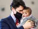 Premierminister Justin Trudeau hält das Kind von Ahmed Hussen, dem Minister für Wohnungswesen, Vielfalt und Inklusion, während einer Pressekonferenz, um im März einen neuen Kinderbetreuungsvertrag mit Ontario anzukündigen.