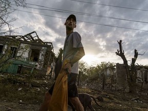 A person walks past the damaged homes from a rocket attack early this morning, Tuesday, Aug. 16, 2022, in Kramatorsk, eastern Ukraine, as Russian shelling continued to hit towns and villages in Donetsk province, regional officials said.