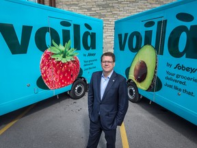 mpire Co. chief executive Michael Medline poses in front of Voilà delivery trucks.