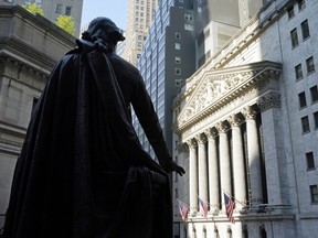FILE - In this June 7, 2021 file photo, The Federal Hall statue of George Washington overlooks the New York Stock Exchange on June 7, 2021, in New York. Democrats have pulled off a quiet first in legislation passed this month: the creation of a tax targeting stock buybacks. The bill includes a new 1% excise tax on companies' purchases of their own shares, a tactic that companies have long used to return cash to investors and bolster their stock's price.